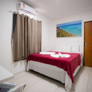 a bedroom with a bed with a red blanket at Pousada Villa Costeira in Maragogi