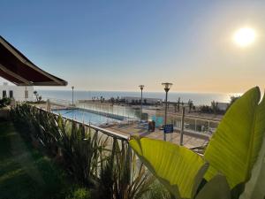 balcón con vistas a la piscina y al océano en Appart de Luxe front de mer Prestigia Plage des Nations en Salé