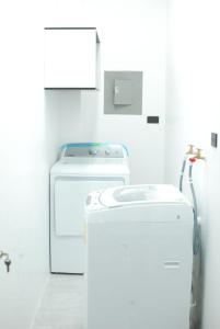 a white laundry room with a washer and dryer at Casa Dome in Santa Elena