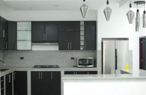 a kitchen with black cabinets and a stainless steel refrigerator at Casa Dome in Santa Elena