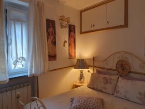 a bedroom with a bed and a lamp and a window at Casa Magnolia in Varese