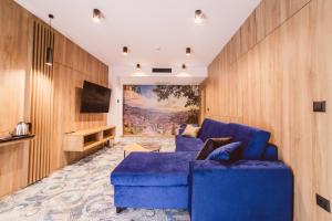 a living room with a blue couch and a tv at Hotel Boutique Anoma in Sarajevo