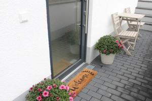 un porche con flores y un cartel que diga patio trasero en Schöne EG-Neubauwohnung in Bad Soden, en Bad Soden am Taunus