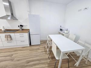 cocina con mesa blanca y nevera blanca en Piso en el centro para 5 Personas - Plaza de Amboage - WIFI, en Ferrol