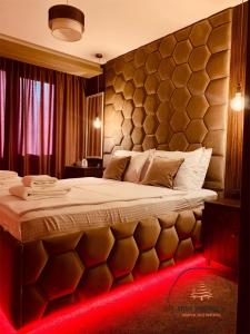 パンポロボにあるDeluxe Apartment 33 Mountain Lodge Pamporovoのベッドルーム1室(赤いライト付きの大型ベッド1台付)