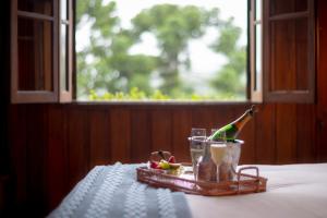 a table with a bottle of champagne and a drink at Alma Hotel in Campos do Jordão