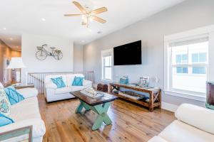 uma sala de estar com mobiliário branco e uma televisão de ecrã plano em Ellie Fish em Gulf Shores