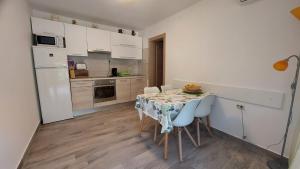 a kitchen with a table and chairs and a white refrigerator at Apartments Nicole in Pula