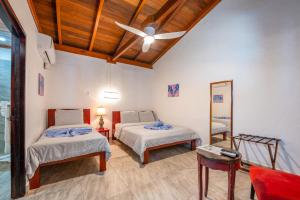 a bedroom with two beds and a ceiling fan at Parrot Cove Lodge in Hopkins