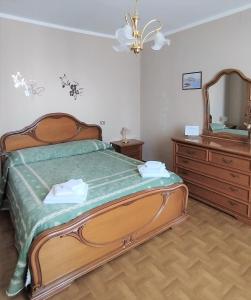 a bedroom with a bed and a dresser and a mirror at Casa alla Costa in Mormanno