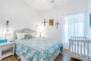 um quarto branco com uma cama e um berço em Ellie Fish em Gulf Shores