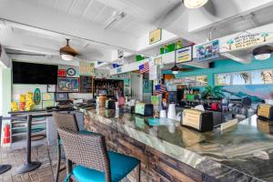 a bar in a restaurant with chairs and a counter at Coastal Charm Hideaway in Key Colony Beach