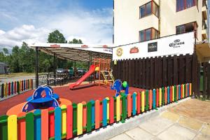 a playground with a colorful fence in front of a building at Hotel Lira in Sunny Beach