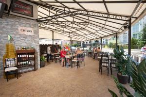 a group of people sitting at tables in a restaurant at Hotel Lira in Sunny Beach