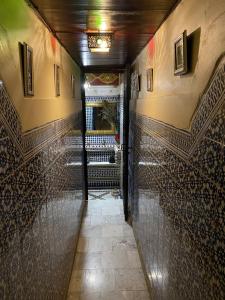 a hallway of a building with a door and tile walls at Riad Taj Salma in Fez