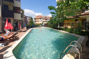 a swimming pool with people laying in the water at Hotel Lira in Sunny Beach