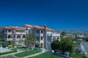 a large mansion with a garden in front of it at Apartments Dunja Piric in Lopar