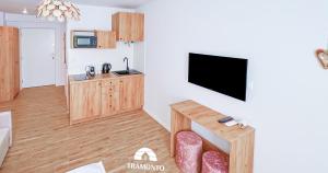 een woonkamer met een flatscreen-tv aan de muur bij Tramonto Apartments Zator Przeciszów in Zator