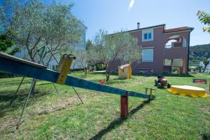 a playground in front of a house at Apartments Dunja Piric in Lopar