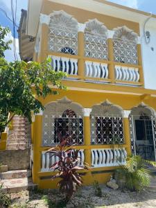 a yellow building with a balcony on top of it at Runthings Hideaway Stay Negril in Negril