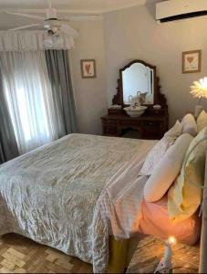 a bedroom with a bed with pillows and a mirror at HYGGE LAS LOMITAS in Lomas de Zamora