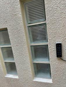 two windows on the side of a building with a remote control at HYGGE LAS LOMITAS in Lomas de Zamora