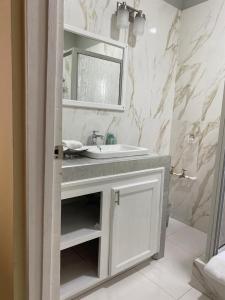 a white bathroom with a sink and a mirror at Runthings Hideaway Stay Negril in Negril