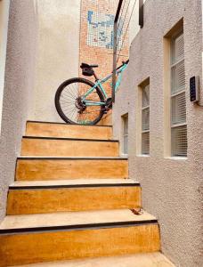 a bike hanging on the side of a building with stairs at HYGGE LAS LOMITAS in Lomas de Zamora
