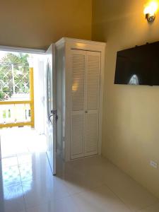 a room with a television and a white door at Runthings Hideaway Stay Negril in Negril