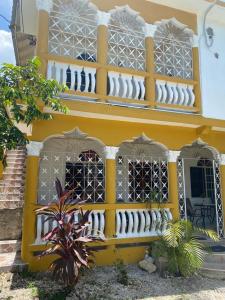 a yellow building with windows and a balcony at Runthings Hideaway Stay Negril in Negril