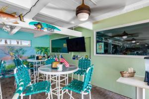 a dining room with blue chairs and a table at Breezy Palms in Key Colony Beach