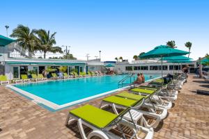 a swimming pool with lounge chairs and umbrellas at Downhome Cabin by the Canal in Key Colony Beach