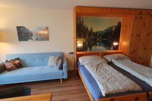 1 dormitorio con cama y sofá en Ideal für gemütliche Ski-, Wander-, und Bergferien, en Disentis