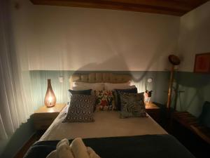 une chambre avec un lit avec des oreillers dessus dans l'établissement Linda vista para as montanhas a 5 min da cidade, à Santo Antônio do Pinhal 38 autres photos