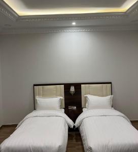 2 Betten nebeneinander in einem Zimmer in der Unterkunft أحلى الليالي للشقق الفندقية in Yanbu