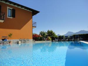 a large swimming pool with chairs and a building at Hotel Adler in Menaggio