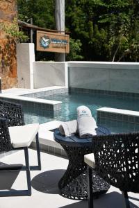 einen Hut auf einem Tisch neben einem Pool in der Unterkunft Pousada Bahia Inn in Morro de São Paulo