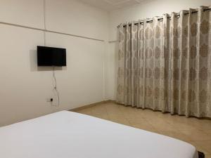 Schlafzimmer mit einem Bett und einem Flachbild-TV in der Unterkunft Two Bedroom Space Near KNUST & CCC in Kumasi