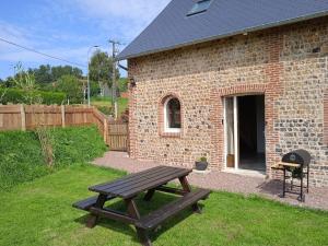 a picnic table in front of a brick building at Le Gîte Du Jardin in Colleville