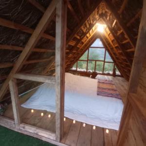 een bed op de zolder van een boomhut bij Gocta Dulce Hogar in Cocachimba