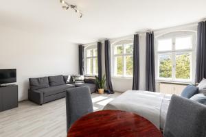 ein Wohnzimmer mit einem Sofa und einem TV in der Unterkunft Apartments am Fernsehturm in Berlin