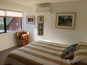 a bedroom with a bed and a chair and a window at Ryland Estate Guest Apartment in Kaituna
