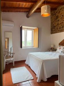 a bedroom with a white bed and a window at Casa do Forte Elvas in Elvas