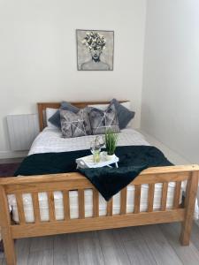 a bedroom with a wooden bed with a tray on it at De Luxe Aparthotel in Leicester