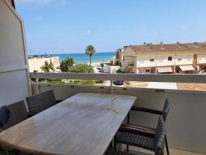 - une table en bois sur un balcon avec vue sur l'océan dans l'établissement apartamento con vistas al mar a pocos metros de la playa, à Valence