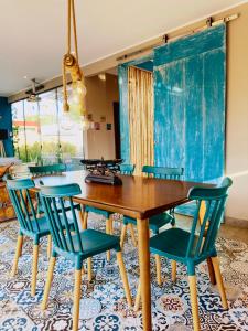 jadalnia z drewnianym stołem i niebieskimi krzesłami w obiekcie La Turquesa w mieście Ica