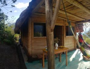 a wooden cabin with a table in front of it at Gocta Dulce Hogar in Cocachimba
