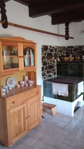 uma cozinha com um fogão e uma parede de pedra em Vidiecky domček na samote 