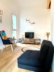 - un salon avec un canapé et une télévision dans l'établissement HARITZAGA chambre d'hôte avec terrasse, à Biarritz