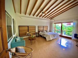 a bedroom with a bed and a couch and chairs at Luxury Villa In Provenza in Medellín +56 photos